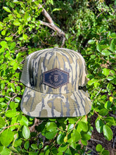 Load image into Gallery viewer, KT Team Lost Hat CO Slate Mossy Oak Bottomland &amp; Balsa Hat w/KT Team Leather Logo Patch
